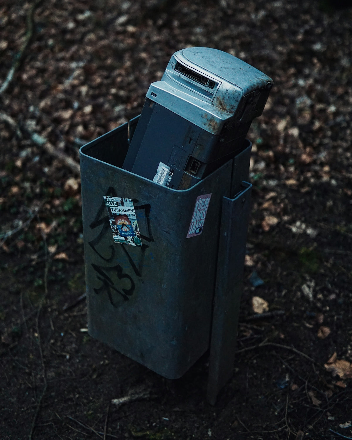 black trash bin on brown dried leaves