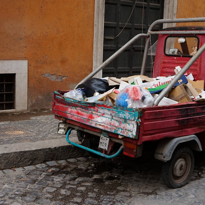 red and black car with garbage bags on top