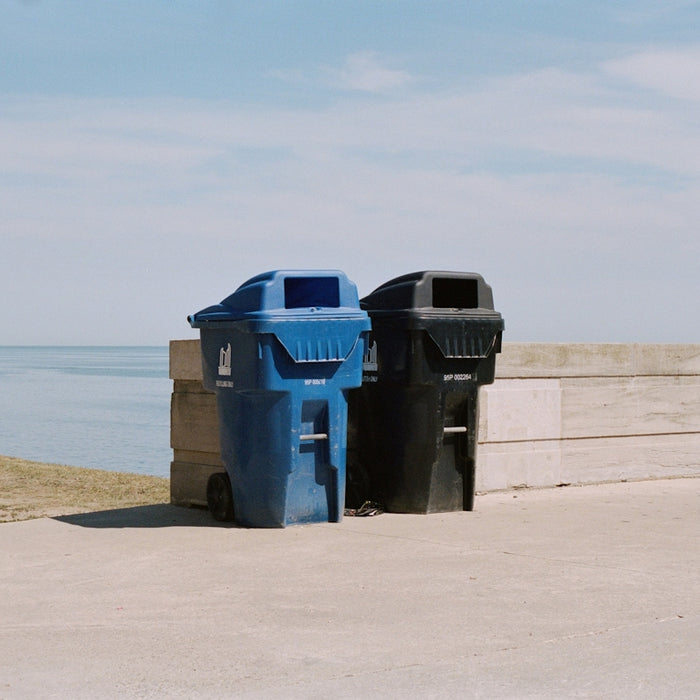 blue trash bin on beach during daytime