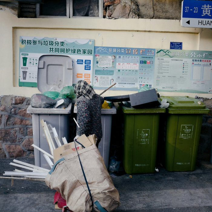 a person pushing a cart full of garbage