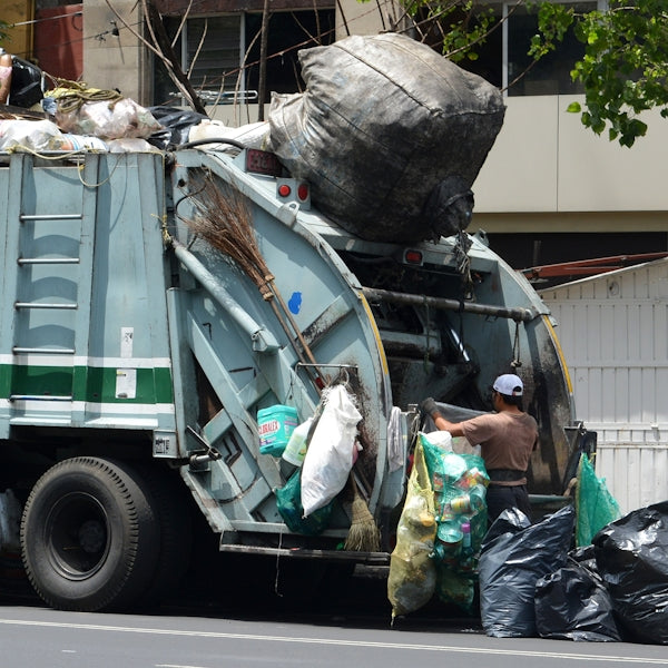 man in green jacket standing beside green truck during daytime