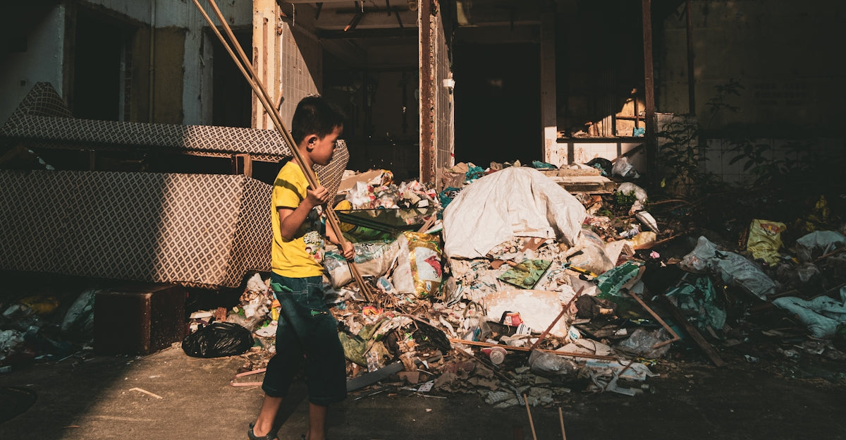 man in yellow t-shirt and black shorts standing near garbage