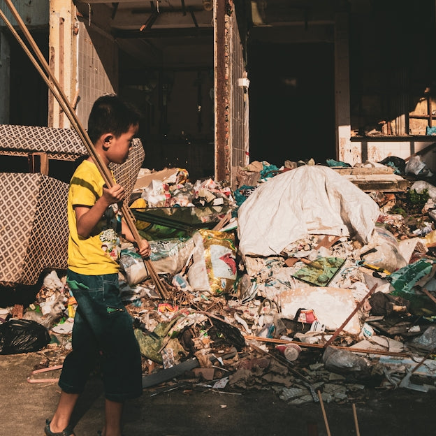 man in yellow t-shirt and black shorts standing near garbage