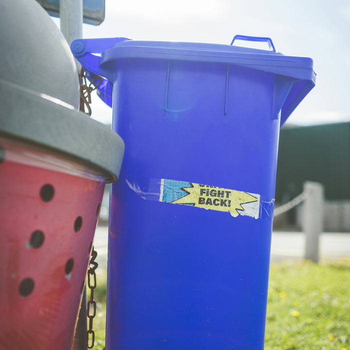 a blue trash can sitting next to a red trash can