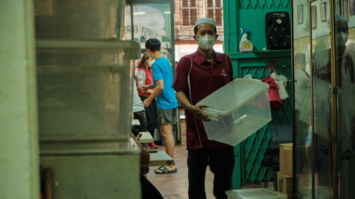 a man wearing a face mask and carrying a plastic container