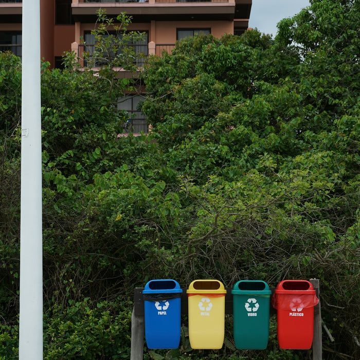 a row of trash cans sitting on top of a sandy beach