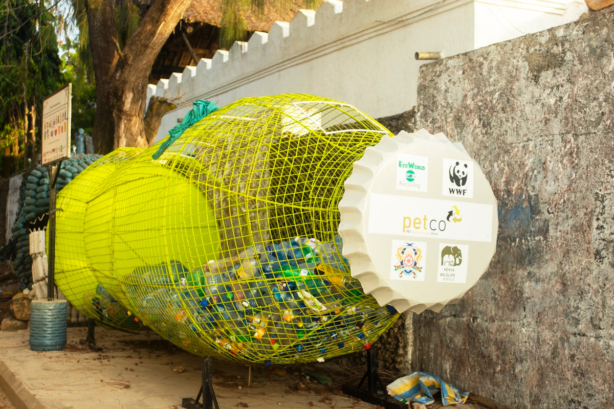 a yellow bird cage sitting on the side of a building