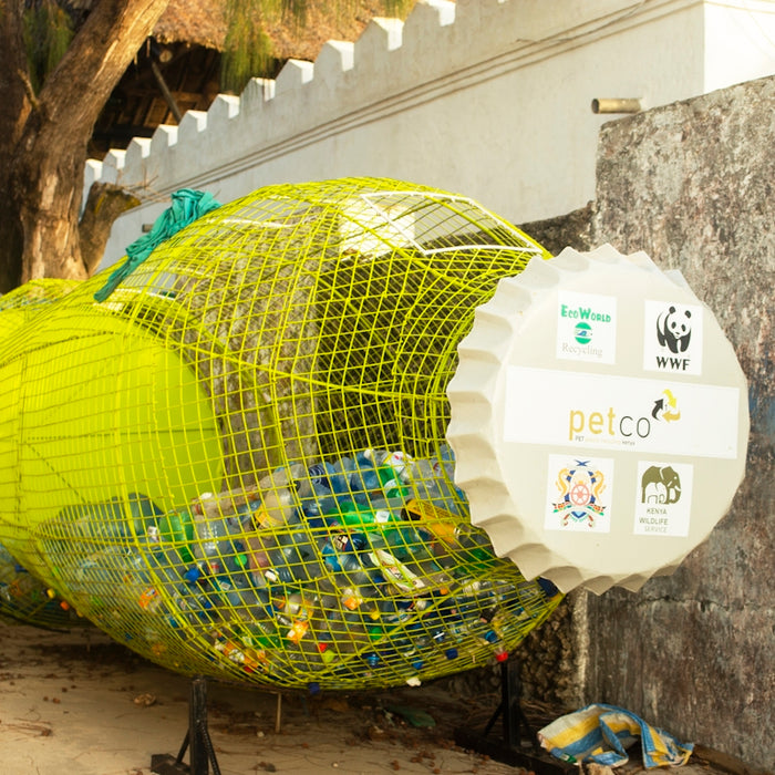 a yellow bird cage sitting on the side of a building