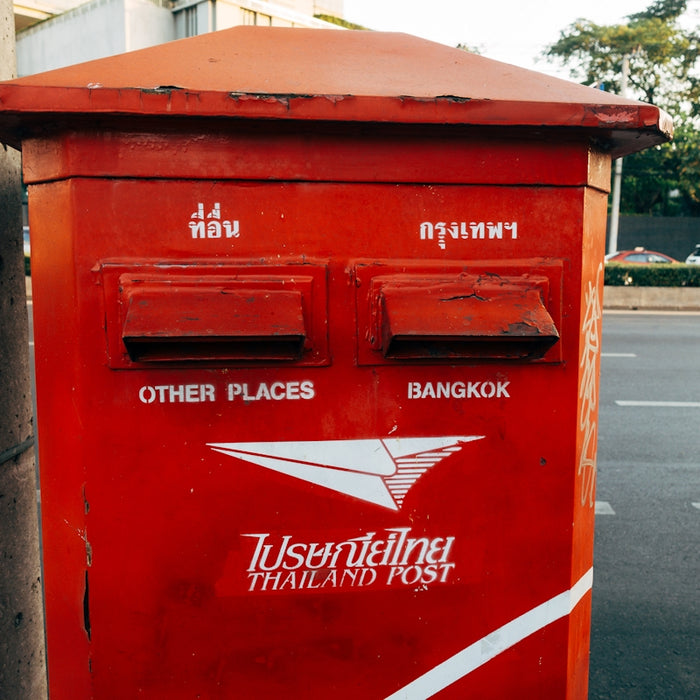 a red mailbox sitting on the side of a road