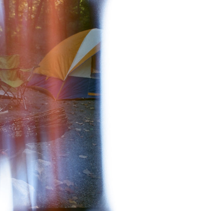 a blurry image of a tent and a campfire