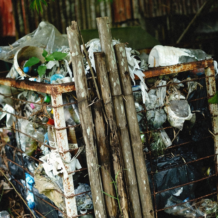 a pile of trash sitting next to a metal fence