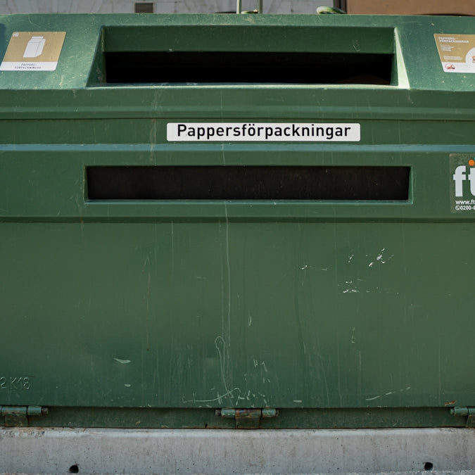 a row of green trash cans sitting next to each other