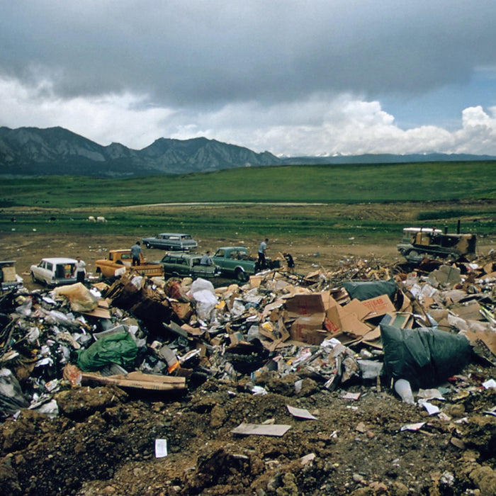 a large pile of trash sitting on top of a dirt field