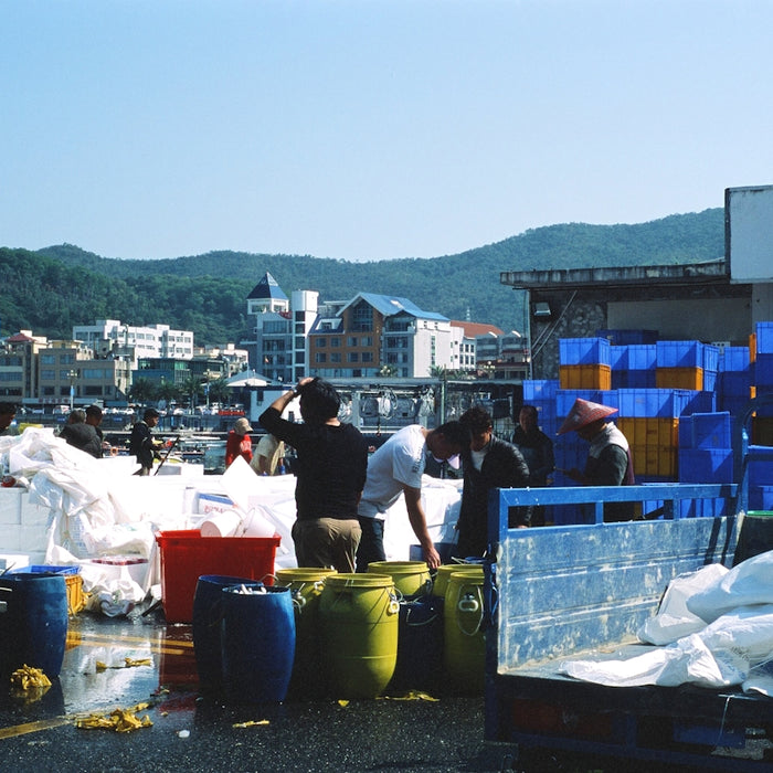 a group of people loading containers onto a truck