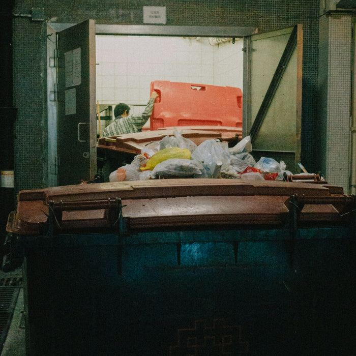 a man standing next to a pile of garbage