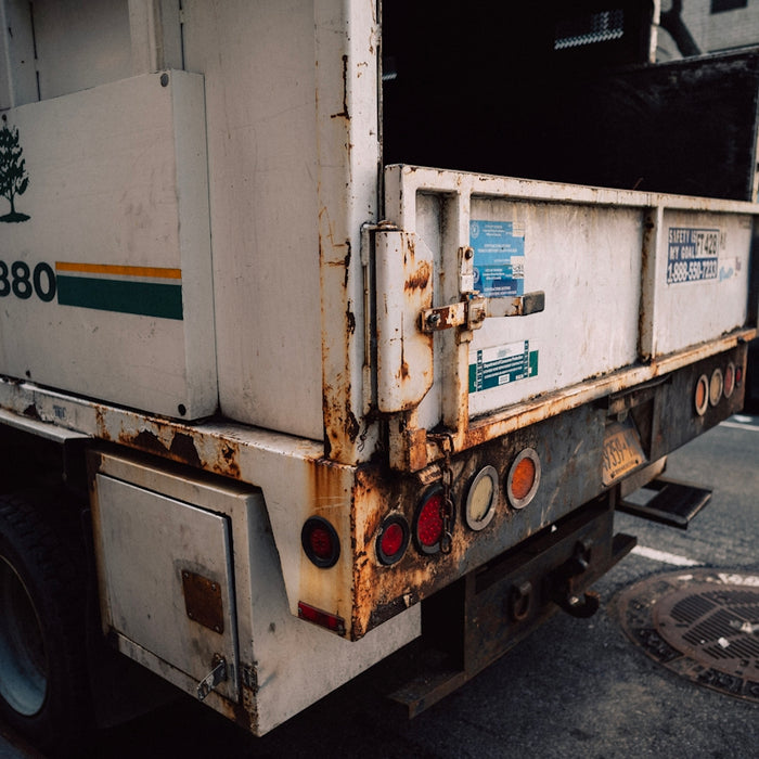 a garbage truck parked on the side of the road