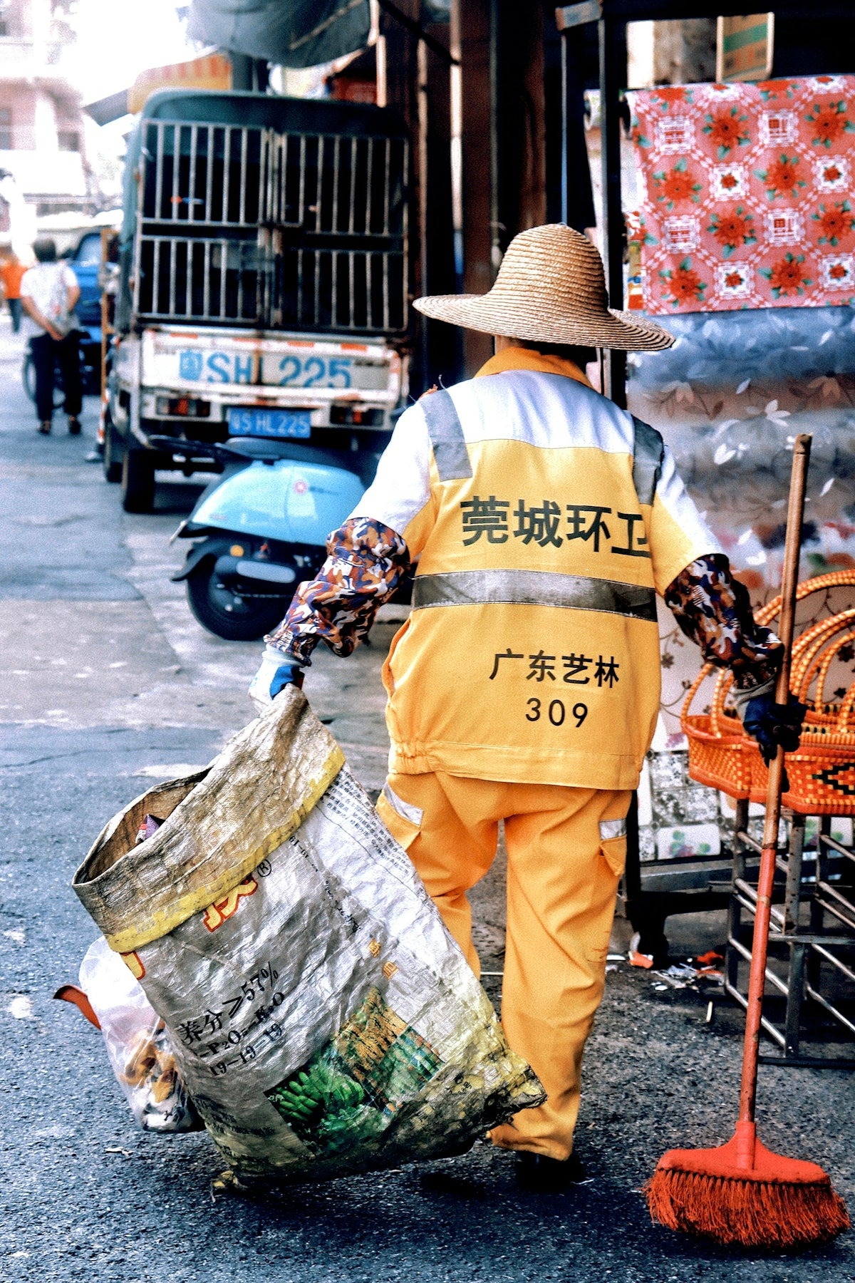 a man with a broom is walking down the street