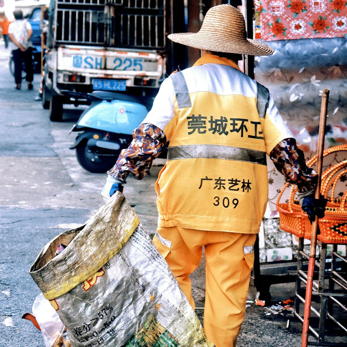 a man with a broom is walking down the street