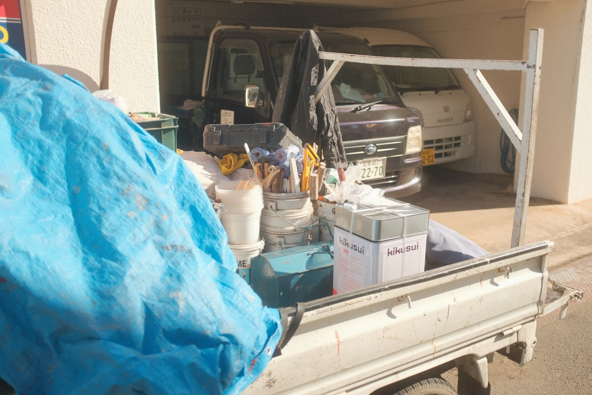 a white truck with a blue tarp on the back of it