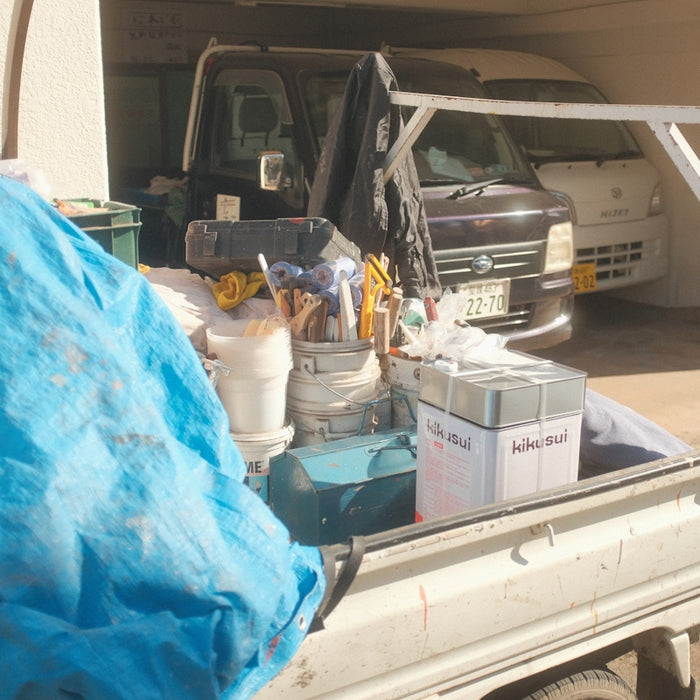 a white truck with a blue tarp on the back of it