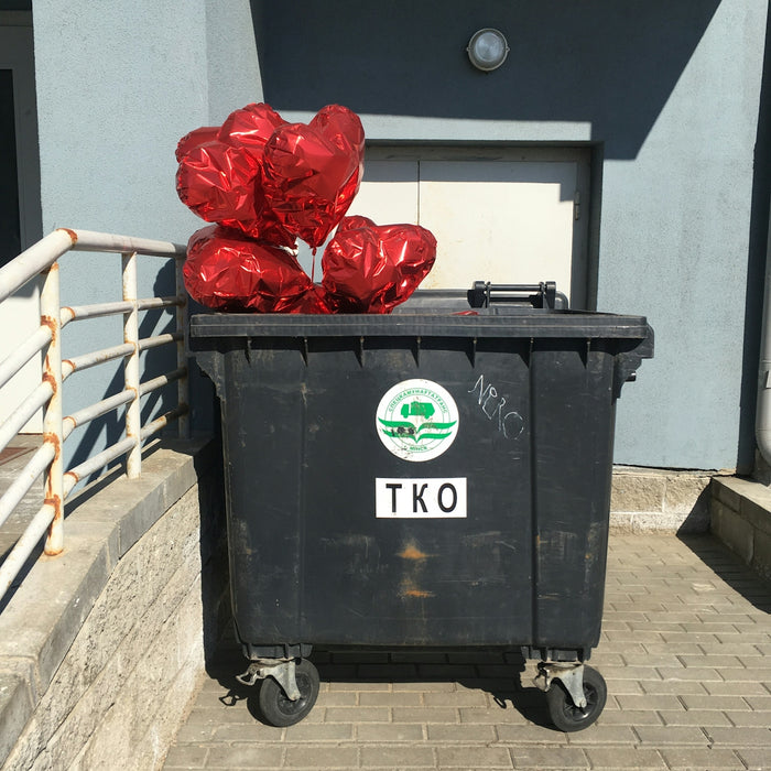 a black trash can with red foil wrapped around it
