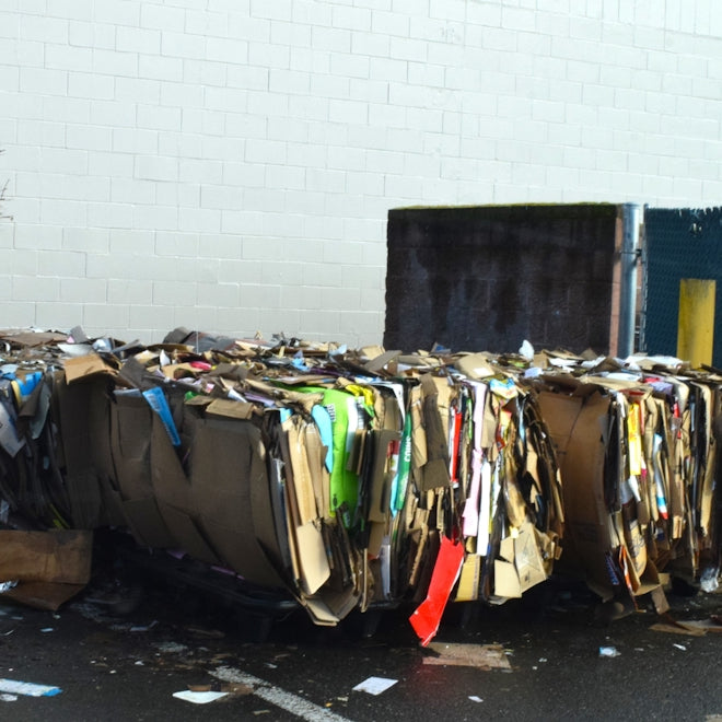 a pile of trash sitting next to a blue trash can