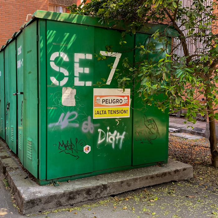 a green trash can with graffiti on it