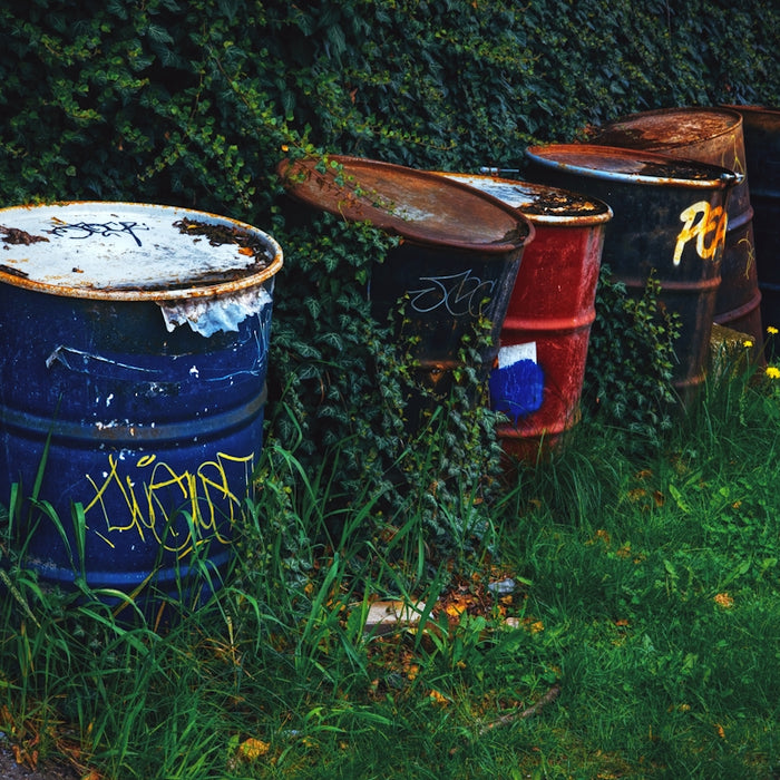 a row of trash cans sitting on top of a lush green field
