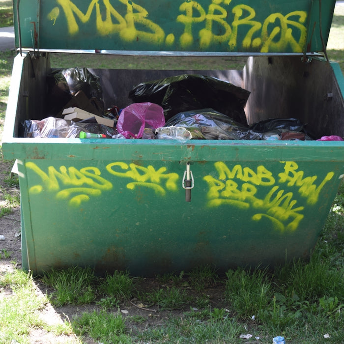 a green trash can with graffiti on it