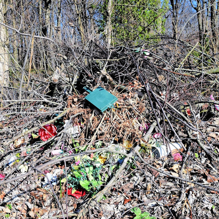 A pile of trash sitting in the middle of a forest