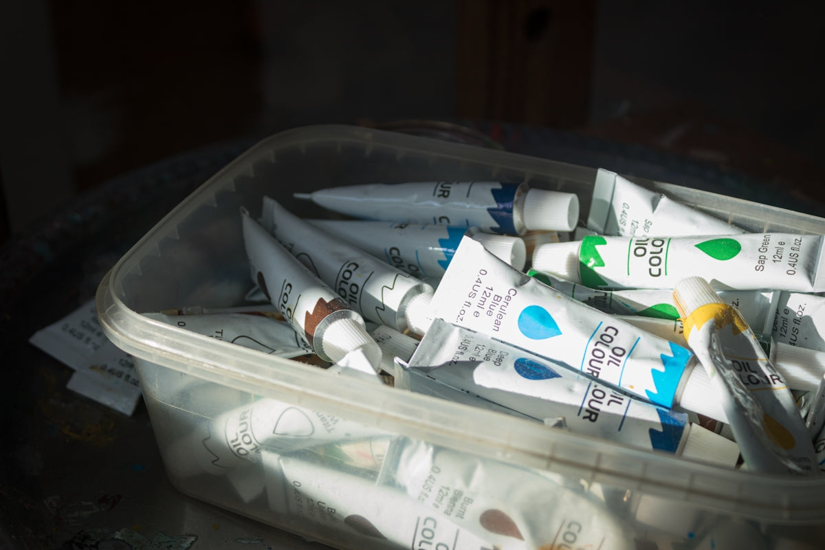 A plastic container filled with toothpaste and toothbrushes