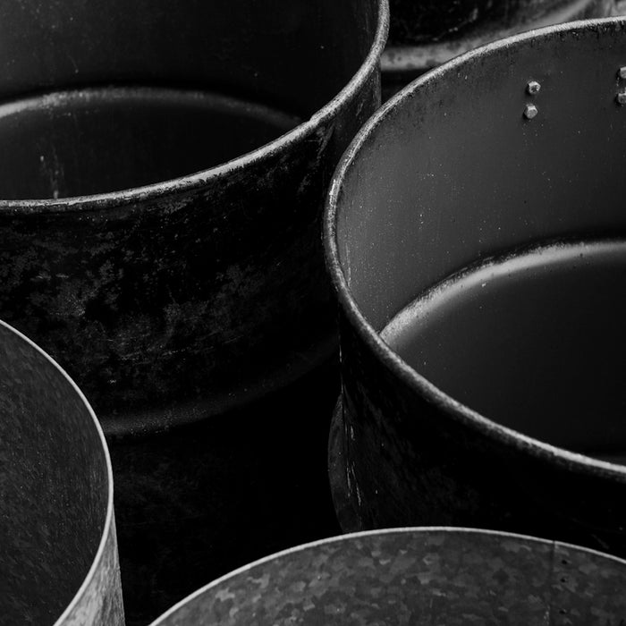Old, empty metal containers are depicted in black and white.