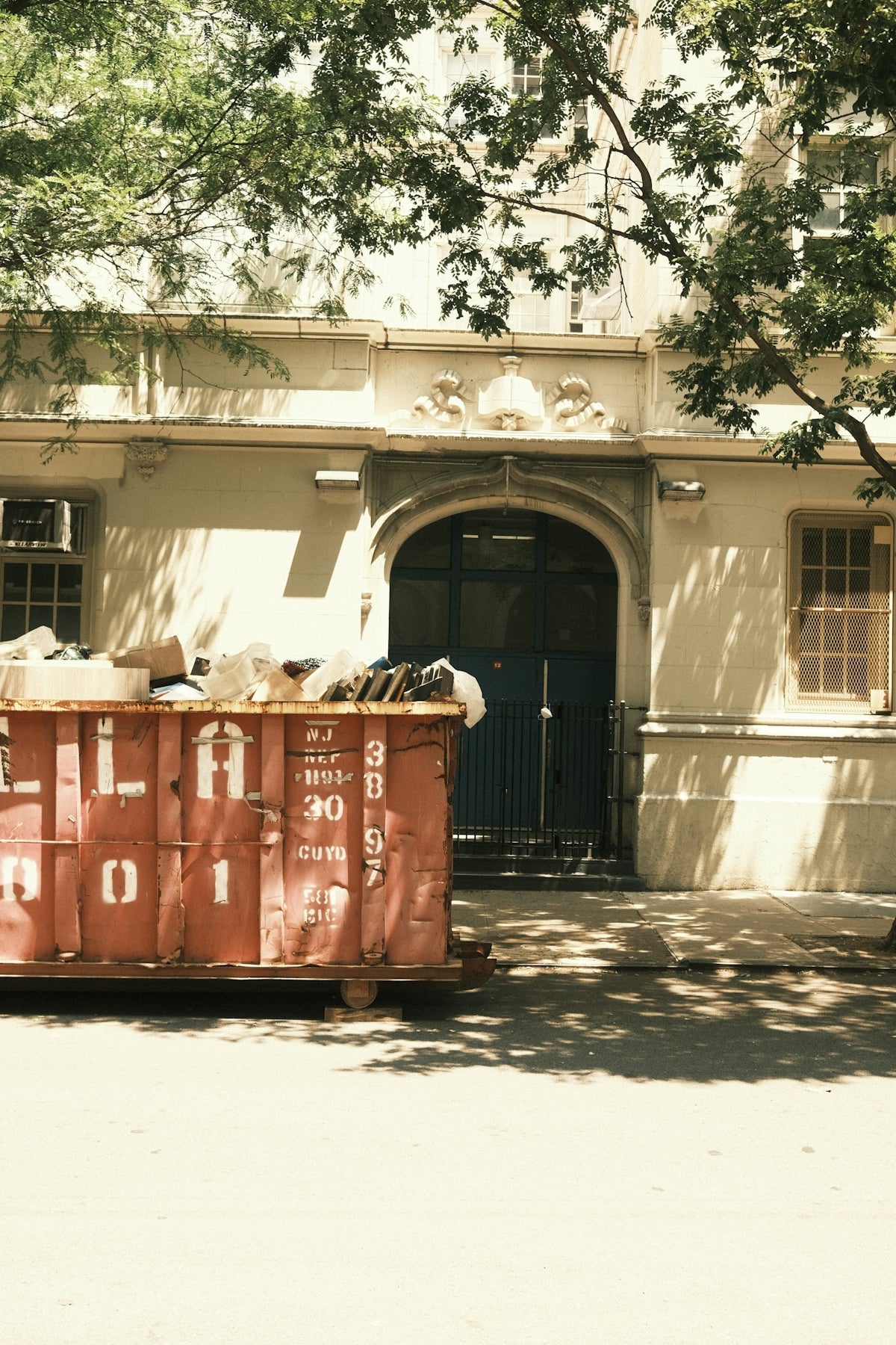 Old building entrance with a dumpster in front.
