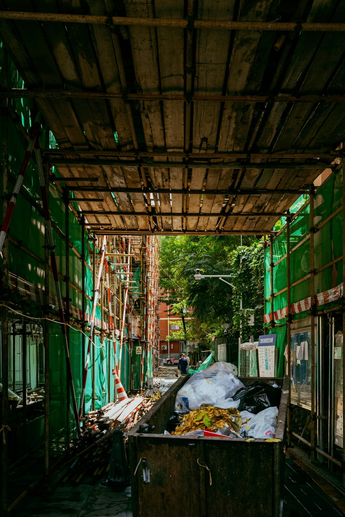 Construction site alley with a dumpster.