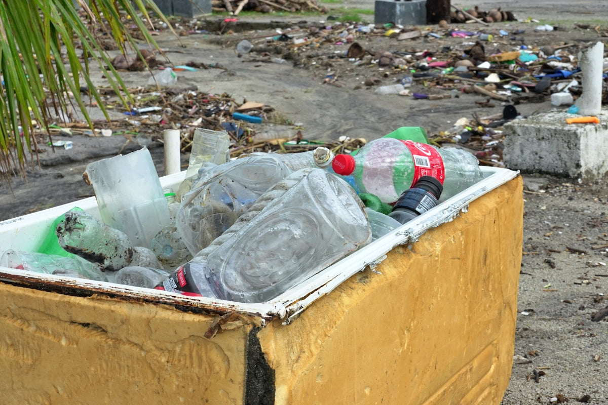 Trash filled cooler on a debris strewn beach