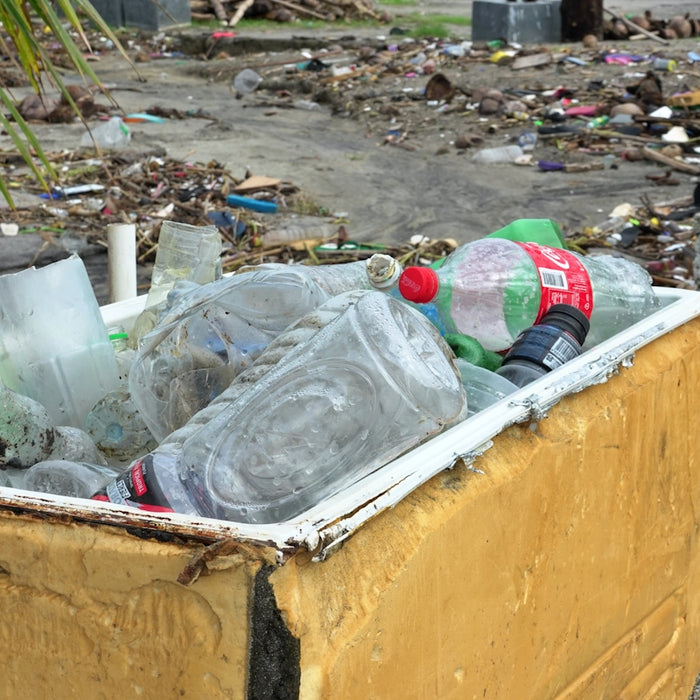 Trash filled cooler on a debris strewn beach