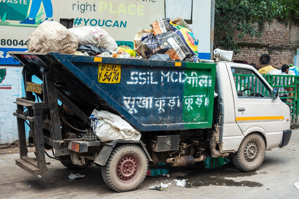 A garbage truck filled with trash on a street.
