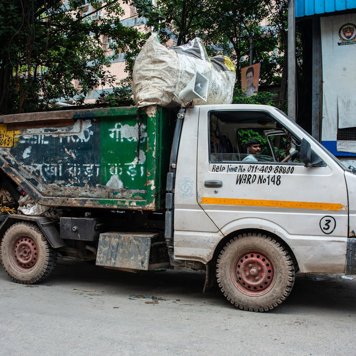 A white garbage truck filled with trash.