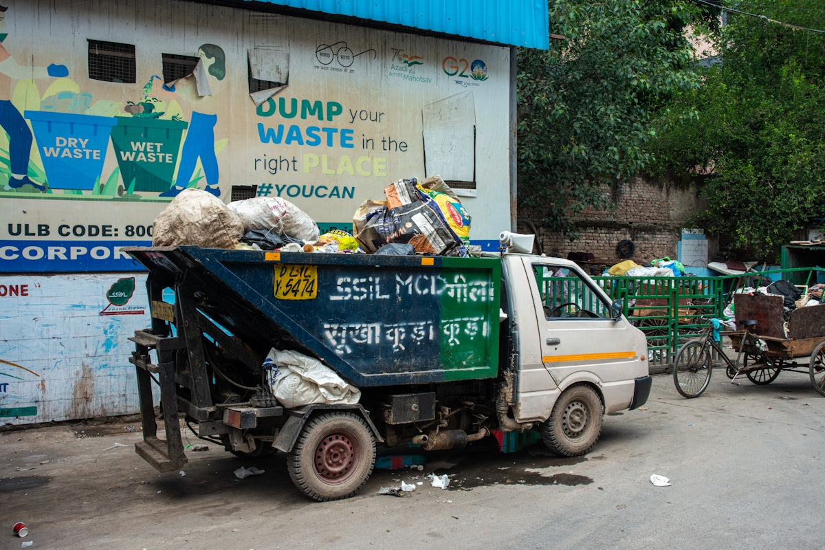 A garbage truck filled with trash on a street.