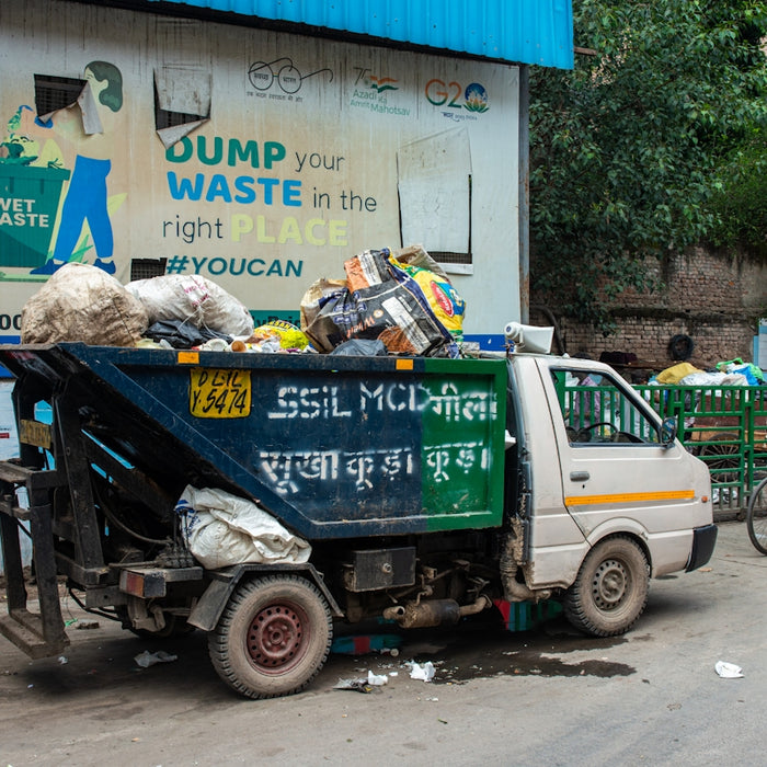 A garbage truck filled with trash on a street.