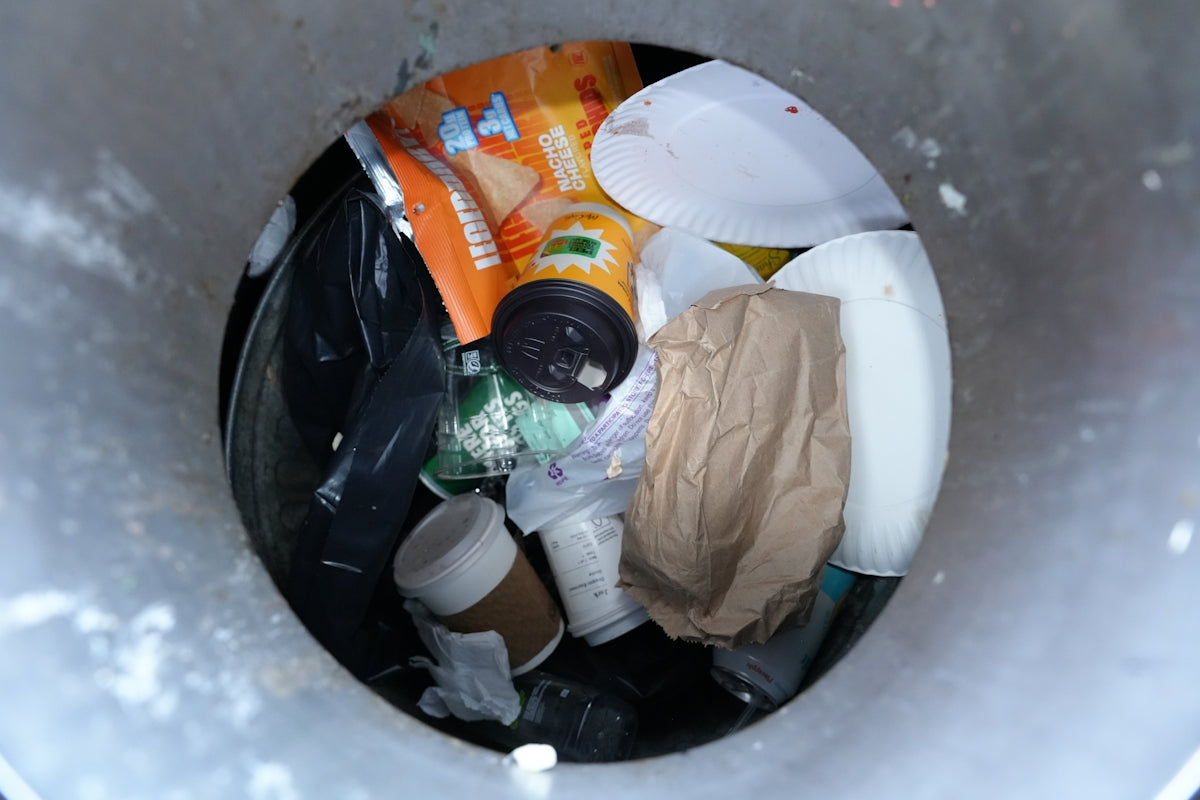 Trash can filled with various discarded items.