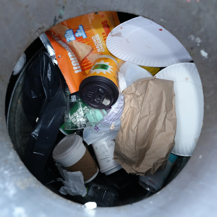 Trash can filled with various discarded items.