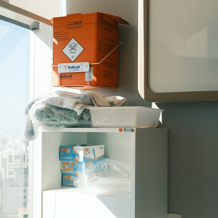 Orange biohazard bin above medical supplies