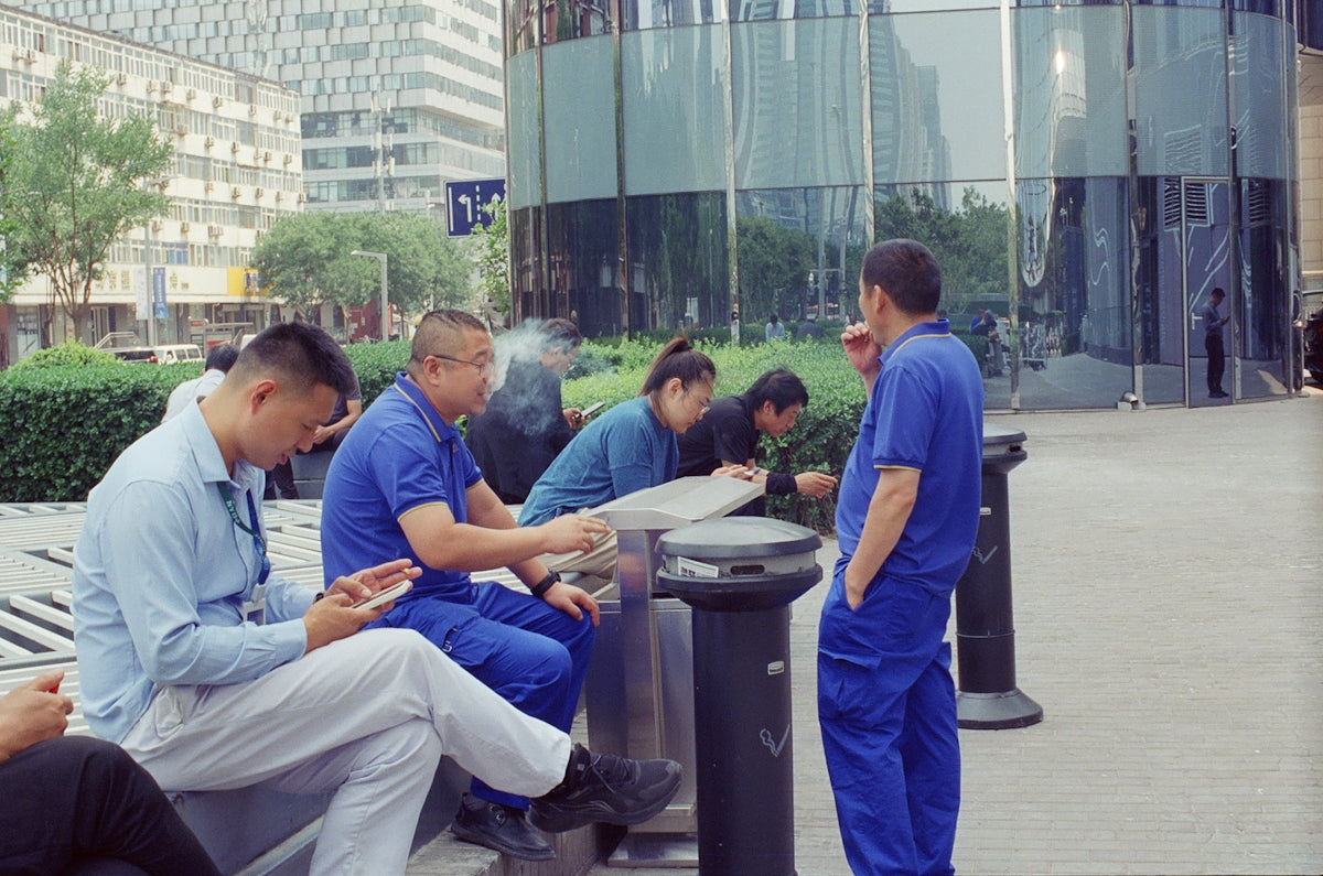 Workers in blue uniforms taking a break outside.